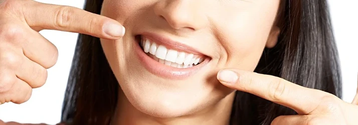 Dentist Topsham ME Close-up of a Woman Smiling While Pointing at Her Teeth Close-up of a Woman Smiling While Pointing at Her Teeth