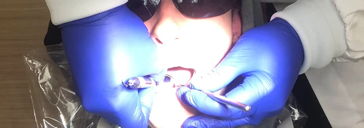 Dentist Topsham ME Patient with Sunglasses is Getting Worked on by Dental Professional with Blue Gloves Patient with Sunglasses is Getting Worked on by Dental Professional with Blue Gloves